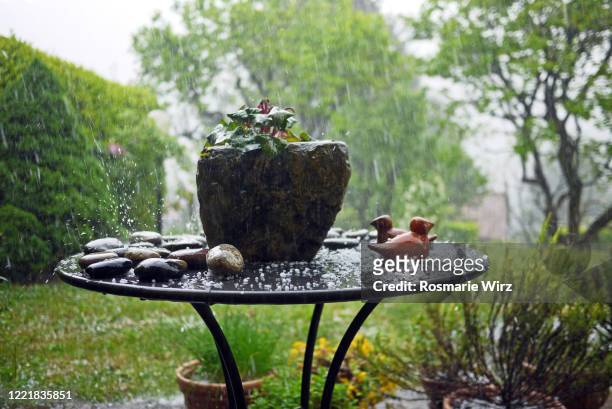 garden table covered with hail stones - hagelschauer stock-fotos und bilder