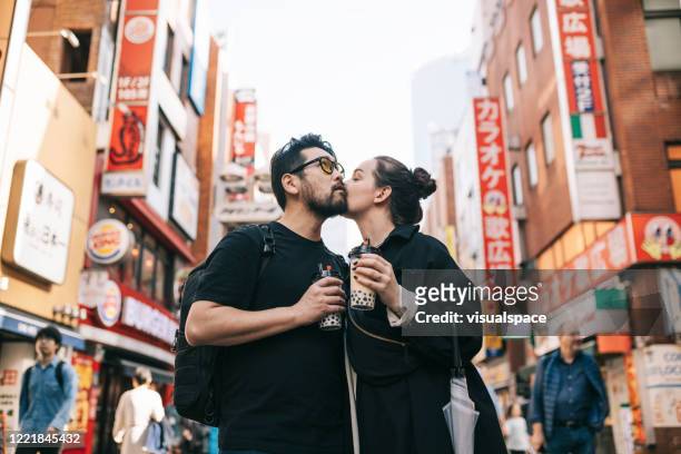 paar dat van hun vakantie geniet - asian couple kissing stockfoto's en -beelden