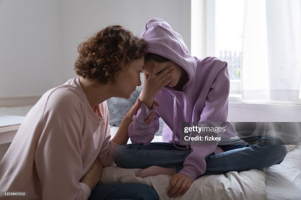 擔心媽媽安慰沮喪的少女女兒在家裡哭泣