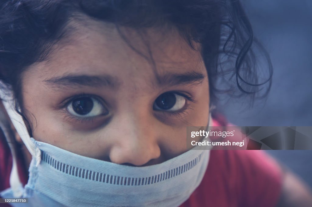 Corona virus COVID-19 epidemic outbreak quarantine concept of cute sick little girl wearing protection medical mask