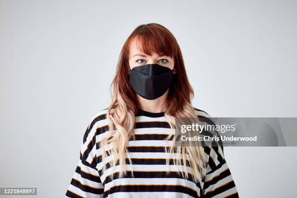 woman intensely staring at the camera, wearing face mask during the pandemic lockdown - nottinghamshire stock pictures, royalty-free photos & images