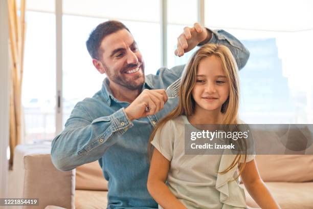 padre che pettina i capelli della figlia piccola a casa - combing foto e immagini stock