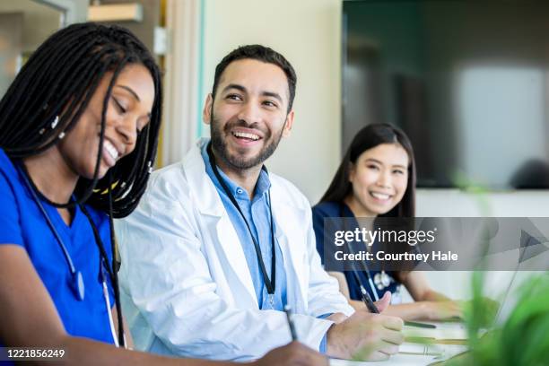 medical students smile during meeting in conference room - young adult at doctor stock pictures, royalty-free photos & images