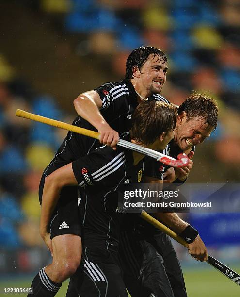 Florian Fuchs of Germany and team mates Linus Butt and Moritz Fuerste celebrate after winning the Men's Eurohockey 2011 semi final match between...