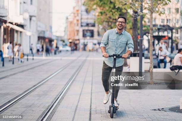 a modern way to move around the city - man with scooter stock pictures, royalty-free photos & images