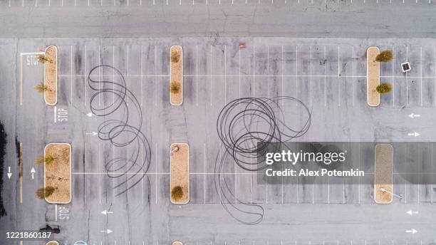 reifenspuren auf dem asphalt, die von radfahrern hinterlassen wurden, die den parkplatz vor dem geschlossenen business-center für drift und rennen nutzten.
extra groß genähtpanorama. - schneewehe stock-fotos und bilder