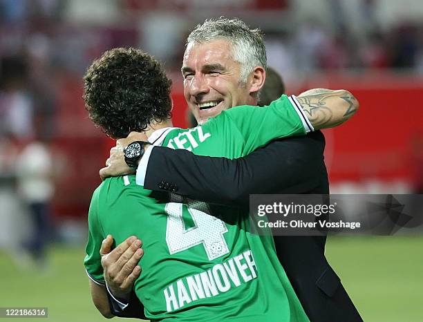 Trainer Mirko Slomka and Amanuel Pogatetz hugging after the UEFA Europa League Play-Off second leg match between FC Sevilla and Hannover 96 at...