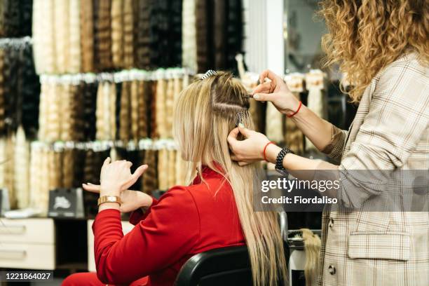 girl hairdresser doing hairstyle styling for a middle-aged woman in a beauty salon - frau blond perücke stock-fotos und bilder