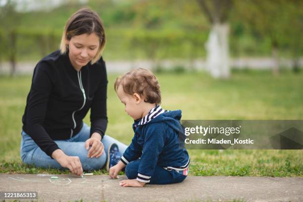 madre e hijo, niño toodler, jugando en un patio trasero - toodler fotografías e imágenes de stock