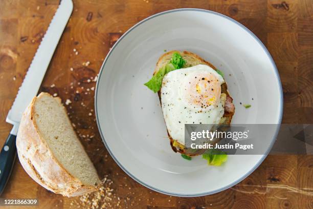 fried egg on homemade toasted bread - bread knife stock-fotos und bilder