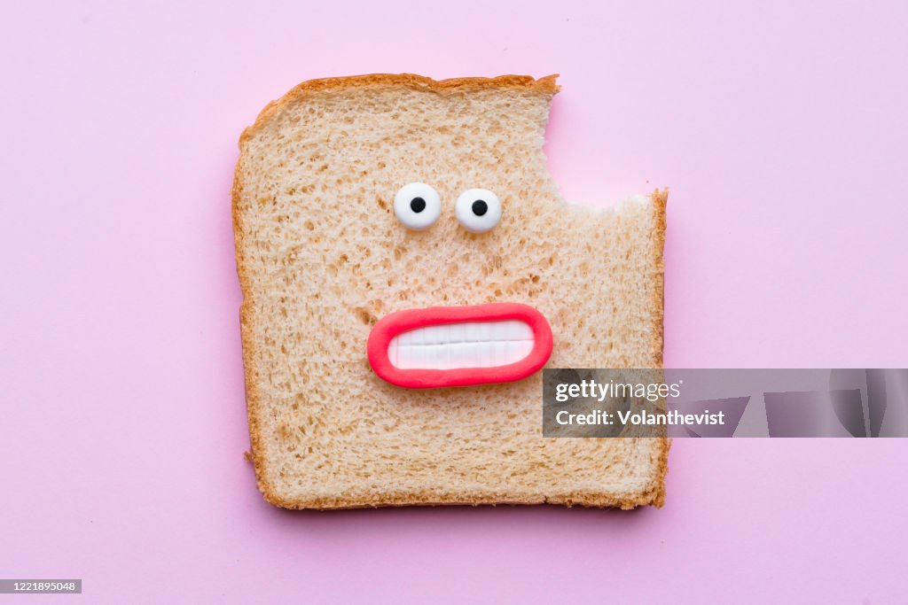 Sliced bread with faces on pink background