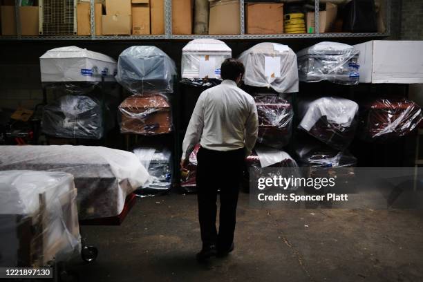 James Harvey tends tends to the inventory of pre-sold caskets at a funeral home on April 29, 2020 in New York City. The funeral home, which serves a...