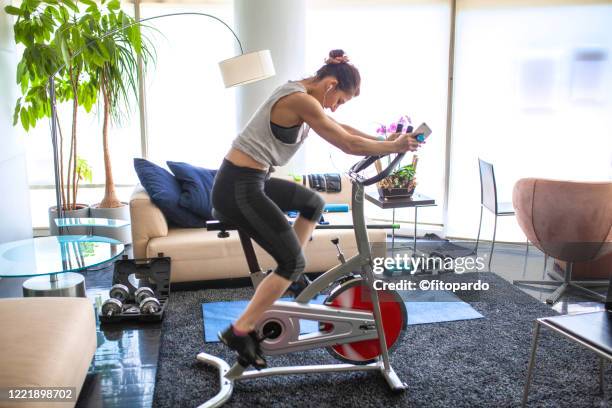 home gym cycing indoors at living room - peloton bildbanksfoton och bilder