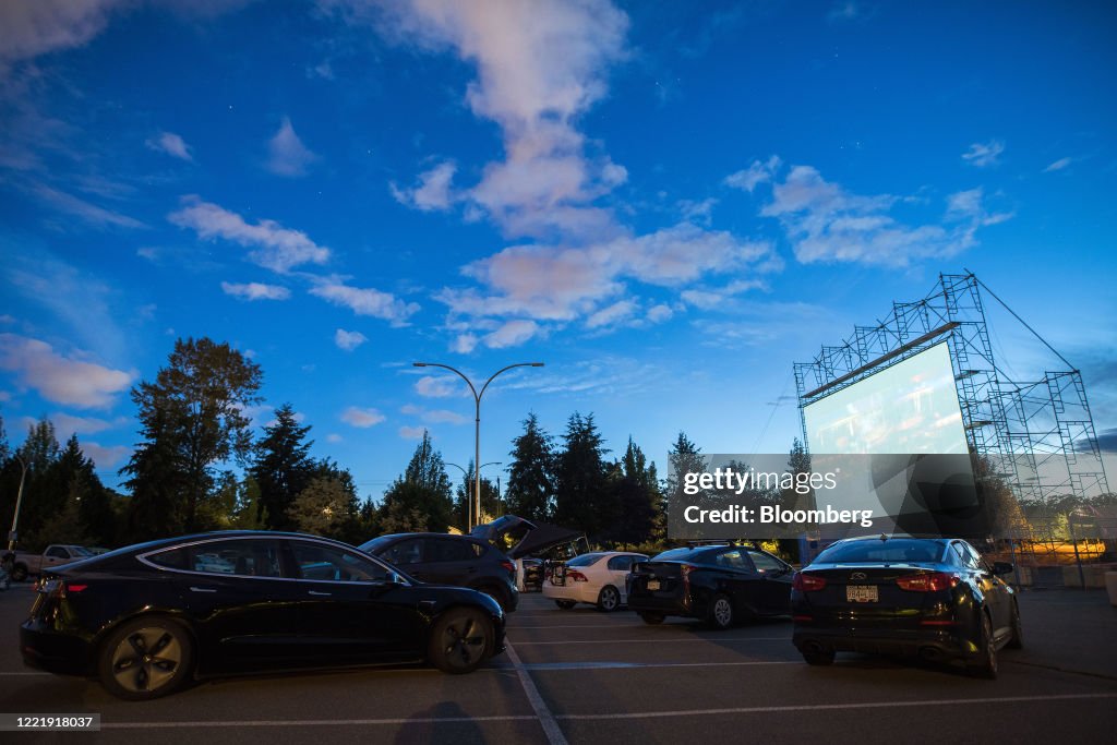 Drive In Cars sit parked in front of the screen at a drive-in movie theater in ...