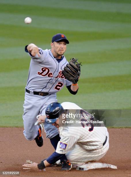 Justin Morneau of the Minnesota Twins is out at second as Ryan Raburn of the Detroit Tigers turns a double play in the first inning on August 26,...