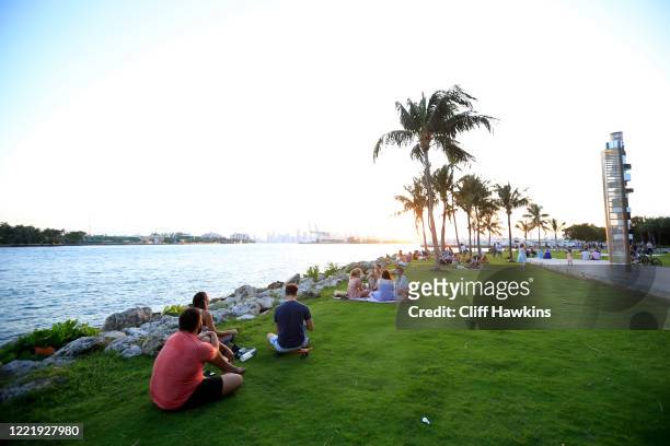 People gather for sunset in South Pointe Park on April 29, 2020 in Miami Beach, Florida. The city of Miami Beach partially reopened parks and...