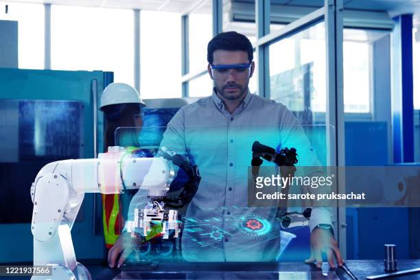 industrial engineer works on the personal computer designing tool part in 3d, using robot . - future factory stock pictures, royalty-free photos & images