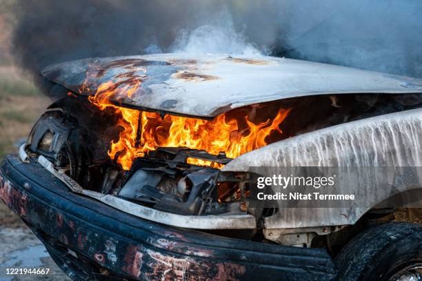 close-up of burning car engine after a frontal crash collision on the roadside with flame and smoke. - vehicle hood stock-fotos und bilder