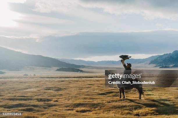 eagle hunter near the river in mongolia - hunter brown stock pictures, royalty-free photos & images