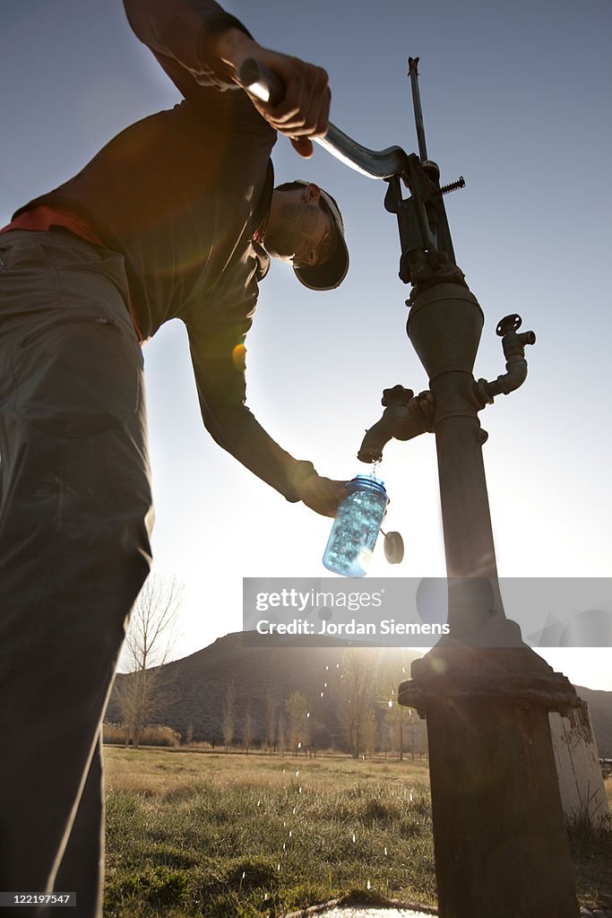 Filling up a bottle by hand pump.