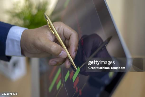 pointing on stock exchange market chart - börsensaal stock-fotos und bilder