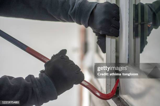 burglar with crowbar trying break the door to enter the house - inbrott bildbanksfoton och bilder