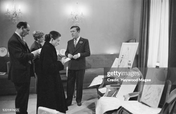 British fashion designer Norman Hartnell , receiving visitors to his Bruton Street salon in Mayfair, London, June 1953. The guests are sketching...