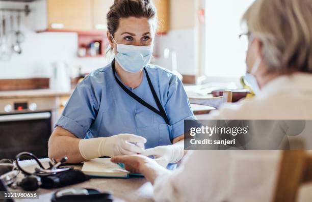 district nurse at home visit - infectious disease mask stock pictures, royalty-free photos & images