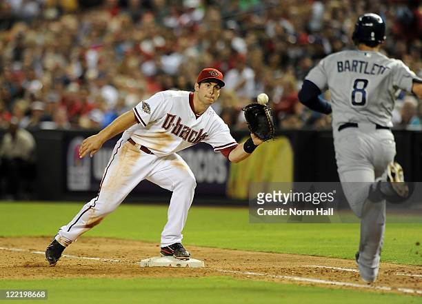 Paul Goldschmidt of the Arizona Diamondbacks watches the ball into his glove as Jason Bartlett of the San Diego Padres hustles down the first base...