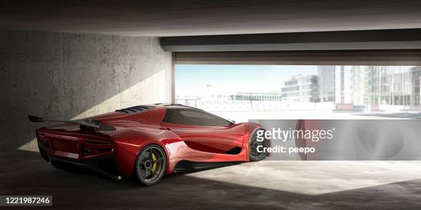 red sports car in open door garage on bright day - muscle car imagens e fotografias de stock