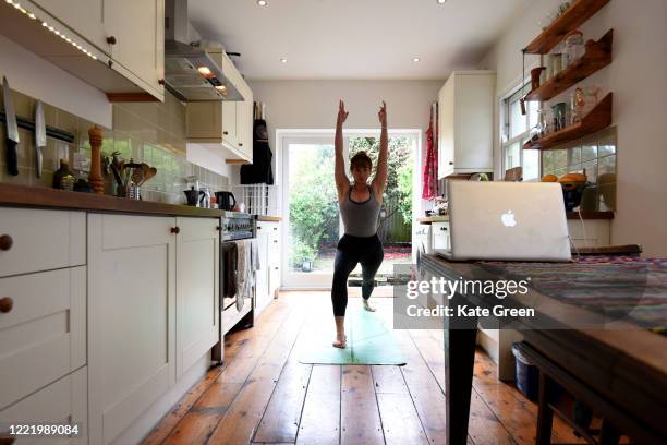 Jessica the photographers housemate, takes part in an online yoga lesson in her kitchen on April 30, 2020 in London, England.