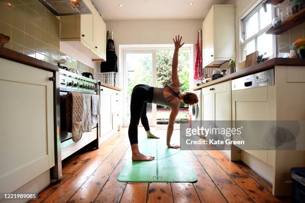 Jessica the photographers housemate, takes part in an online yoga lesson in her kitchen on April 30, 2020 in London, England.