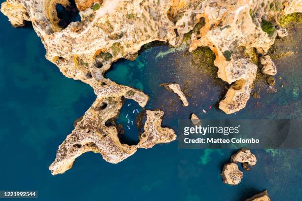 drone view of stand up paddlers among rocks, portugal - ponta da piedade imagens e fotografias de stock