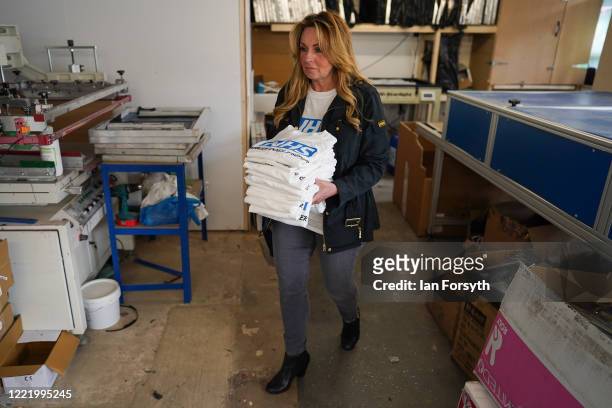 Business owner Alison Hylton carries a finished batch as she produces NHS branded t-shirts on April 30, 2020 in Hartlepool, England. Mrs Hylton’s...