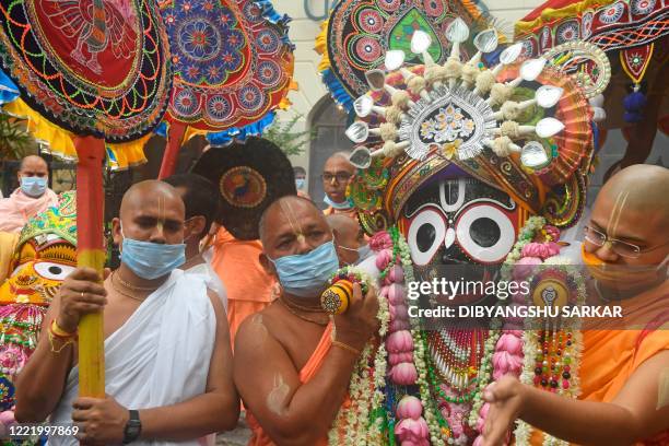 Temple priests and Hindu devotees carry an idol of Lord Jagannath as a symbolic gesture after the Rath Yatra procession was cancelled amid concerns...