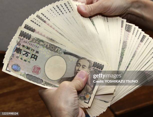 Bank teller counts 10,000 yen bank notes in Tokyo on September 22, 2010. The USD tumbled against the yen in Asia after the US Federal Reserve...