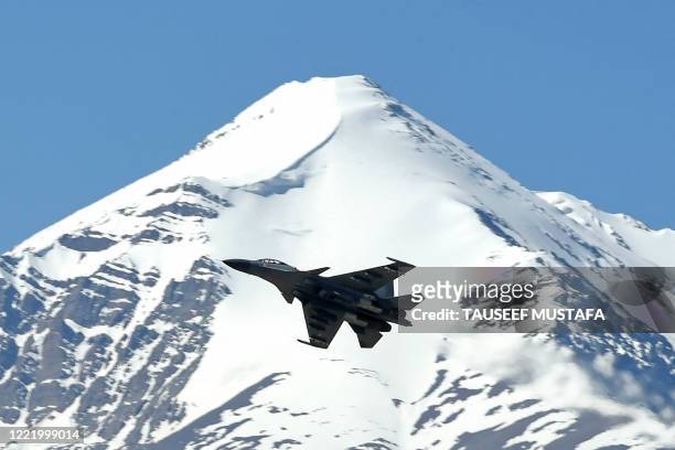 An Indian fighter jet flies over a mountain range near Leh, the joint capital of the union territory of Ladakh, on June 23, 2020. - India's Prime...