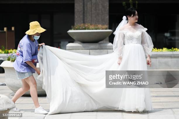Woman wearing a wedding dress waits to have her wedding photos taken in Beijing on June 23, 2020. - Tens of thousands of people in the Chinese...