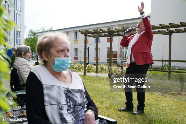 Singer Alf Weiss performs live as residents look on at the Hermann Radtke Haus nursing home during the novel coronavirus crisis on April 29, 2020 in...