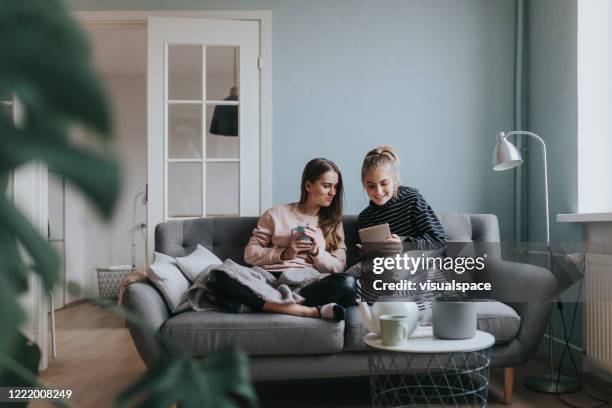 zwei teenager-mädchen mit einem videoanruf zu hause - tea for two stock-fotos und bilder