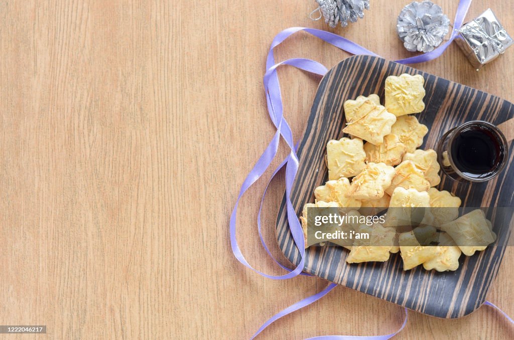 Cheese cookies or biskut keju on the wooden plate and background.