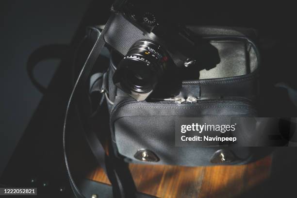 black camera and camera bag - camera bag stock-fotos und bilder