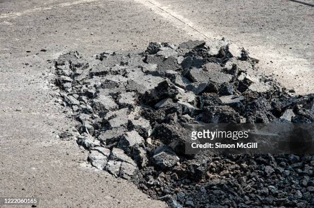 asphalt road broken up by a jackhammer pneumatic paving breaker drill - rubble imagens e fotografias de stock