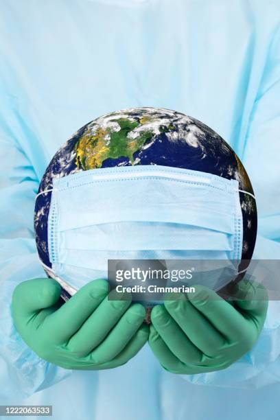 pandemiskt koncept - läkarens händer i handskar som håller planeten jorden i en medicinsk mask - medicinsk procedur bildbanksfoton och bilder
