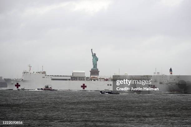 The USNS Comfort hospital ship exits the harbor in front of the Statue of Liberty as it heads back to Naval Station Norfolk in Virginia on April 30,...