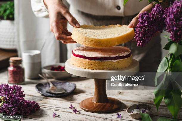 nahaufnahme der köchin, die geschichteten kuchen zubereitet - torto stock-fotos und bilder