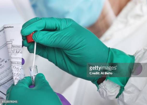 Health Care Worker seals a coronavirus swab after testing at the Pro Health Urgent Care coronavirus testing site on April 30, 2020 in Wantagh, New...