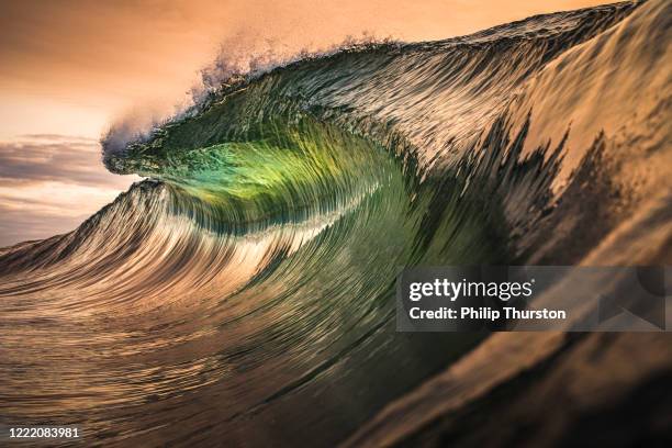 labio dorado de la ola lanzando en el océano - tsunami fotografías e imágenes de stock