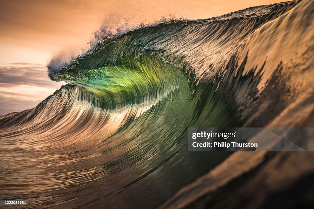 Golden lip of wave throwing in the ocean