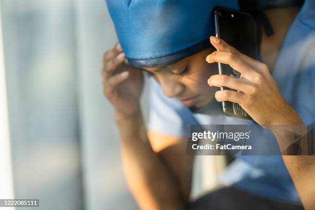 müde arzt aus dem nahen osten, der eine pause eingeht, um einen geliebten menschen anzurufen - op-mundschutz stock-fotos und bilder